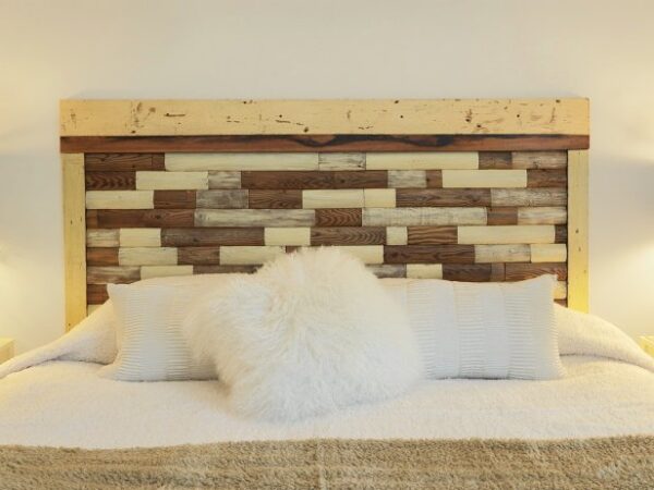 Rustic headboard with cozy white pillows.