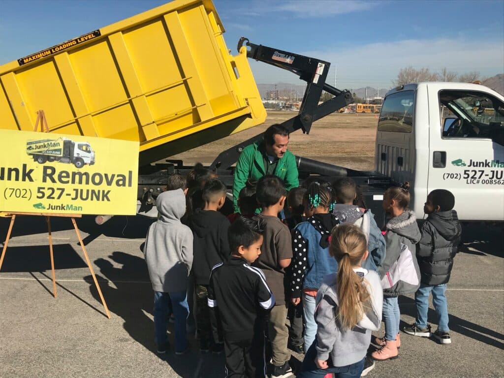 Children learning about junk removal truck with JunkMan's president.